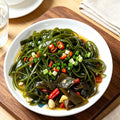 Seaweed salad dressed with chilli and spring onion in a white bowl