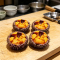 Whole sea urchins filled with deep orange roe
